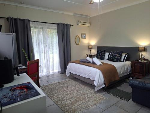 a bedroom with a bed and a tv in it at 1-On-Scott Garden Suites in Somerset East