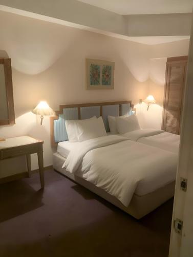 a bedroom with a large bed with white sheets and pillows at 2BR Seaview Condo with Balcony at Riviera Bay Resort, Melaka in Malacca