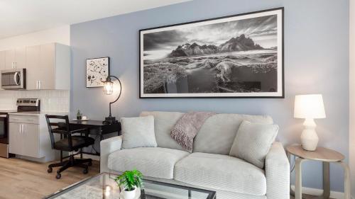 a living room with a white couch and a kitchen at Landing Stylish 2BD Gym Pool in Colorado Springs