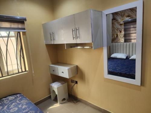 a small room with a bed and white cabinets at The Oasis in Ilorin