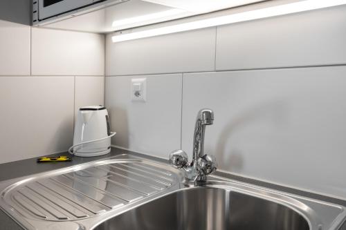 a kitchen sink with a faucet on top of it at Interlaken Apartments in Interlaken