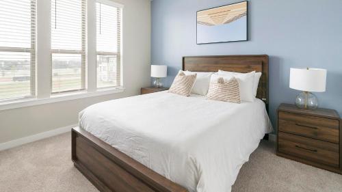 a bedroom with a large white bed with two windows at Landing Incredible 1BD Pool Gym in Katy