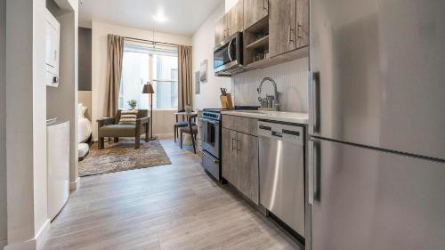 a kitchen with a refrigerator and a sink at Landing Incredible Studio Rooftop Lounge in Denver