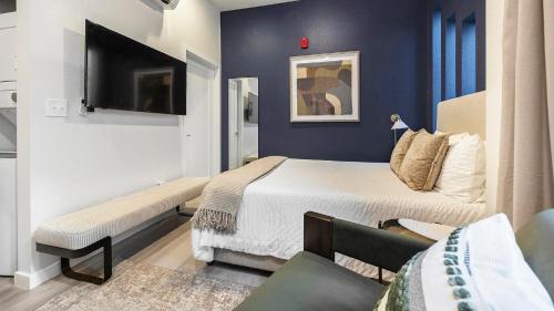 a small bedroom with a bed and a tv at Landing Incredible Studio Rooftop Lounge in Denver