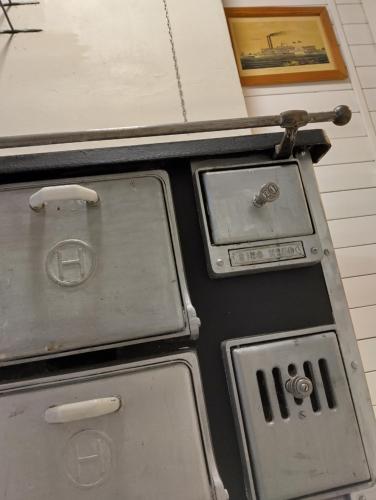 an old stove is sitting next to a painting at Navy Condo for 6, free parking in Turku