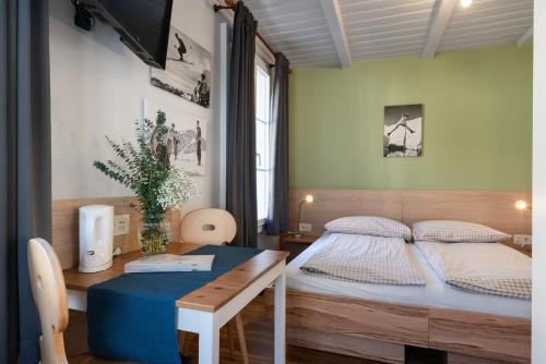 a small bedroom with a bed and a table at Interlaken Apartments in Interlaken