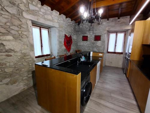a kitchen with a sink and a stone wall at Casa de Santa Luzia B in Caminha