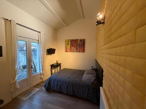 a bedroom with a bed and a large window at Chambre indépendante 1 lit 2 pers maison calme in Romans-sur-Isère