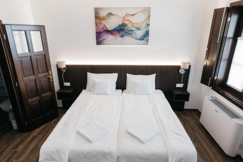 a bedroom with a bed with two white pillows at Szende Vendégház in Villány