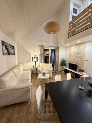 a living room with white furniture and a black table at Prázdninový dům Centrum Pastvinská přehrada in Nekoř