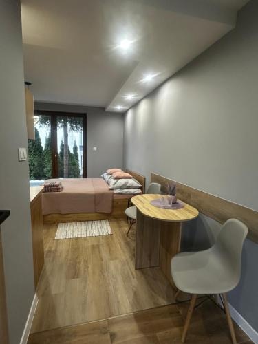 a small room with a bed and a table and chairs at Pokoje na 6a in Wisła