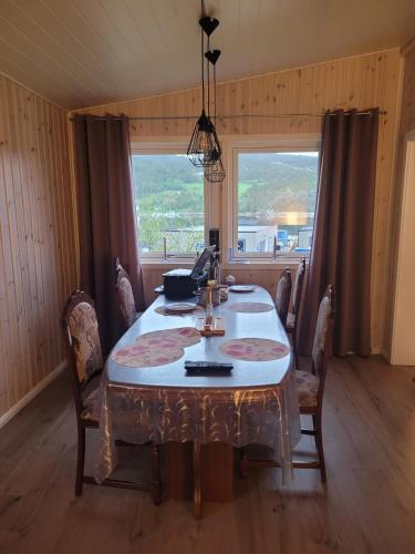 a dining room with a table and a window at Ferienhaus Solli Norwegen in Kolvereid