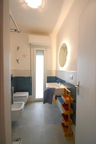 a bathroom with a sink and a toilet and a mirror at Fidelica in Stintino