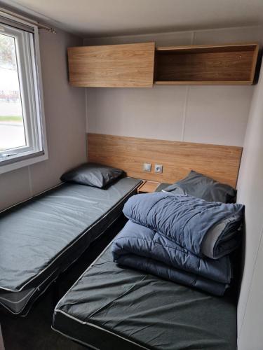 two beds in a small room with a window at Lac des rêves in Lattes