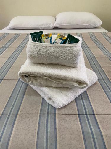 a pile of towels sitting on a bed at Maria Candida Hospedaria in Areias