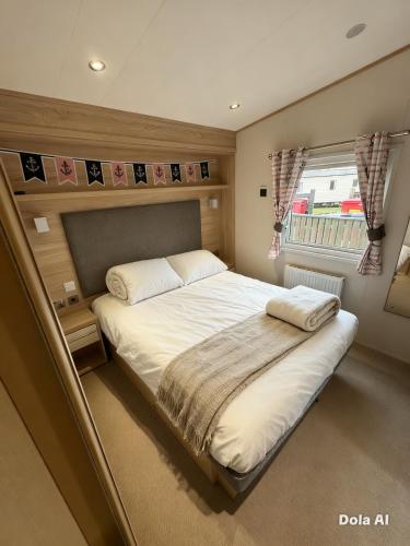 a large bed in a small room with a window at Church meadow 39 in Pagham