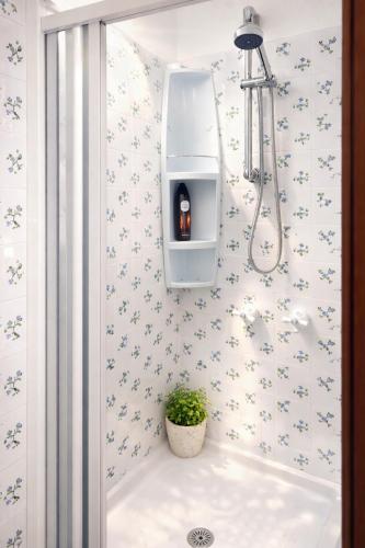 a bathroom with a bath tub with a bottle in a shelf at Casa Vacanze Paola 2 in Santa Luria