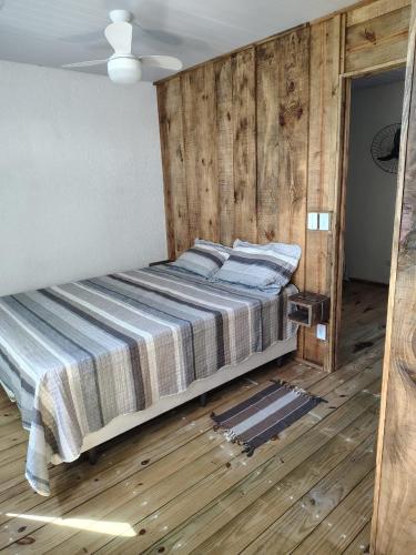 a large bed in a room with wooden walls at Sol de Caraúbas in Caraúbas