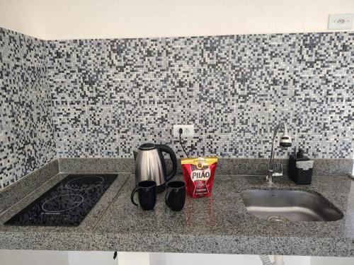 a kitchen counter top with a sink and a stove at Sol de Caraúbas in Caraúbas