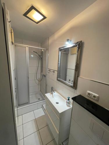a bathroom with a shower and a sink and a mirror at Kleines Glück Grömitz in Grömitz