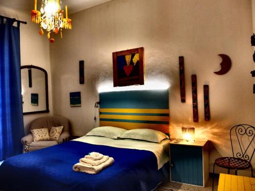ein Schlafzimmer mit einem blauen Bett, auf dem Handtücher liegen in der Unterkunft AlCasart in Alcamo