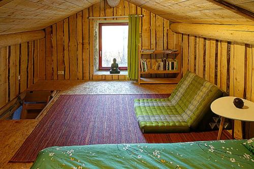 a room with a couch and a table and a window at Maisonnette cocooning, ancien four à pain in Saint-Éloy-la-Glacière