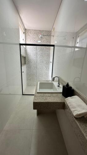 a white bathroom with a sink and a shower at Bela Gold Alto Caparaó in Caparaó Velho