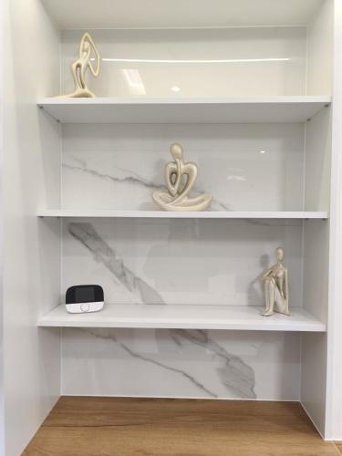 a white shelf with some items on it at Blu Apartments -Rynek in Nowa Ruda