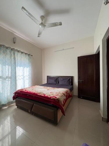 a bedroom with a bed with a red comforter at Namya Villas in Bhīm Tāl