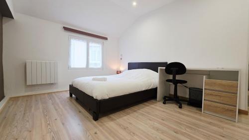 a bedroom with a bed and a desk and a window at Le Grand Minck in Grand-Fort-Philippe