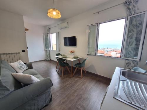 a living room with a couch and a table with chairs at Casa Milda in Sanremo