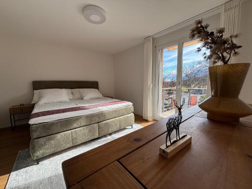 a bedroom with a bed and a vase on the floor at Alpine View Thierachern in Thierachern