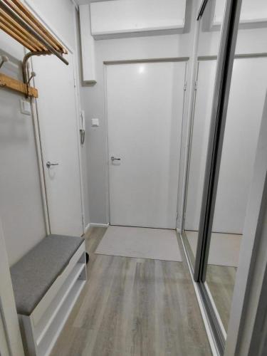 a walk in closet with a door and a bench at Cozy studio near the train station in Lappeenranta