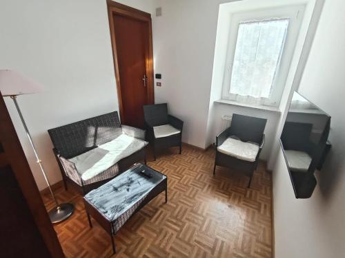 a living room with chairs and a table and a window at Appartamento Conti Schreck in Baselga di Pinè