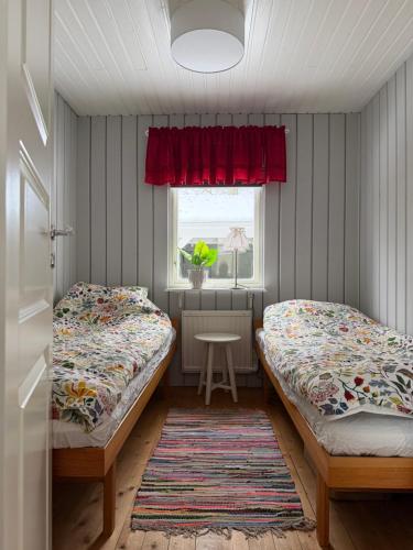 two beds in a small room with a window at Wonderful cottage close to lakes in Södra Rörum