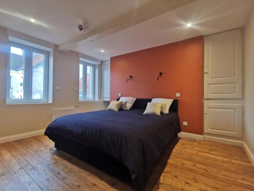a bedroom with a large bed with an orange wall at Premium Appartement Hesdin in Hesdin