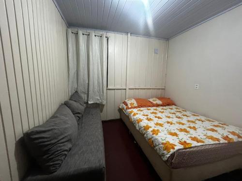 a small bedroom with a bed and a window at Casa da vó in Jaguaruna