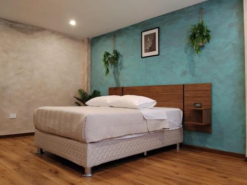 a bedroom with a bed and a blue wall at Hotel Samana'Inn in Arequipa