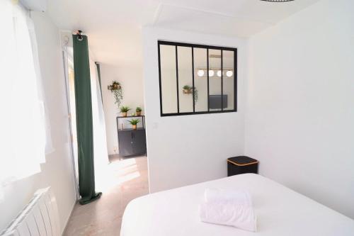 a bedroom with a white bed and a mirror on the wall at La Cosy House in Courcouronnes