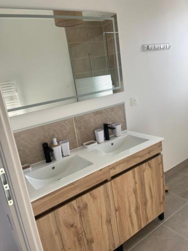 a bathroom with two sinks and a mirror at Petite maison calme in Dun-sur-Auron