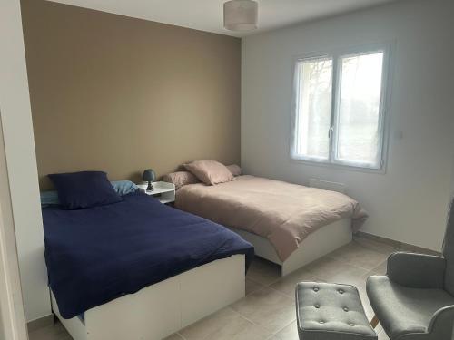 a bedroom with two beds and a window at Petite maison calme in Dun-sur-Auron
