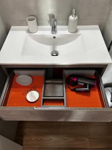 an orange tray underneath a sink in a bathroom at TuttiFruttiaApt in Nerja