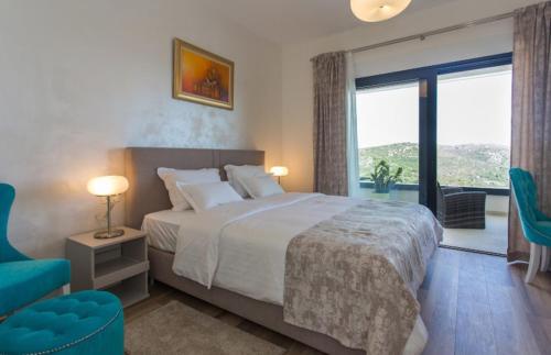 a bedroom with a large bed and a large window at Villa Olive Tree in Vinišće