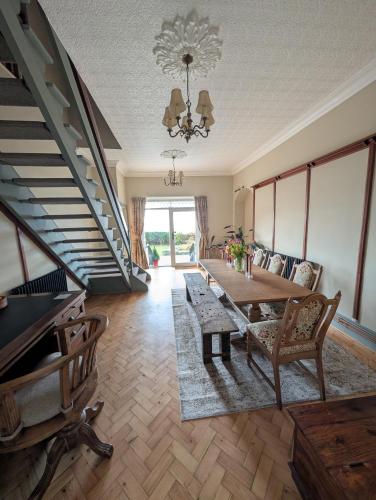 a living room with a table and a staircase at Gower view in Burry Port