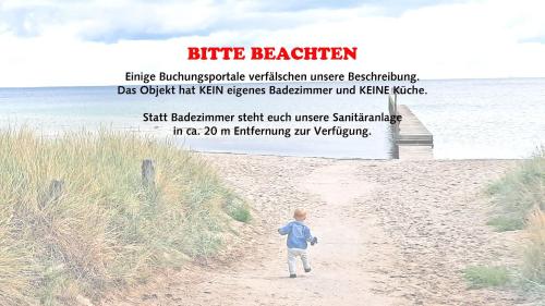 a little boy walking down a sandy beach at Surf Shack 1 - Zimmer nah am Meer, WLAN, Gemeinschaftsgarten, Surfschule, Naturstrand, Parkplatz, Radfahrweg, Promenade in 10 Minuten erreichbar, Stopover Puttgarden in Dahme