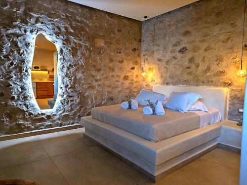 a bedroom with a bed with a rock wall at Megusta Mykonos in Tourlos