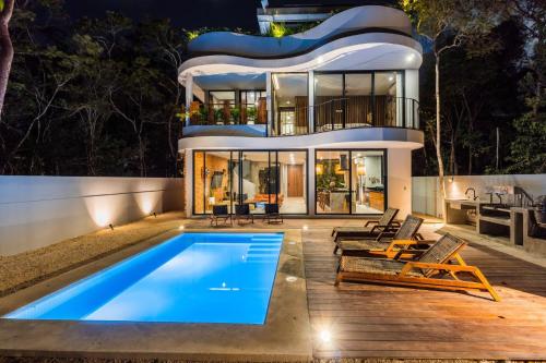 a house with a swimming pool in front of it at Luxury 4BR Eco Villa 10ppl Outdoor Pizza Oven - Private Pool & Jacuzzi in Tulum