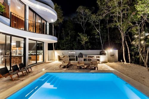 a house with a swimming pool at night at Luxury 4BR Eco Villa 10ppl Outdoor Pizza Oven - Private Pool & Jacuzzi in Tulum