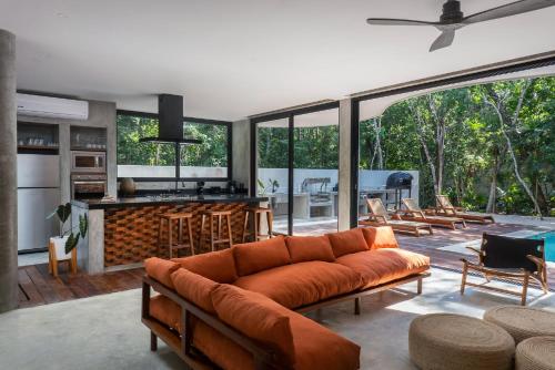 a living room with a couch and a kitchen at Luxury 4BR Eco Villa 10ppl Outdoor Pizza Oven - Private Pool & Jacuzzi in Tulum
