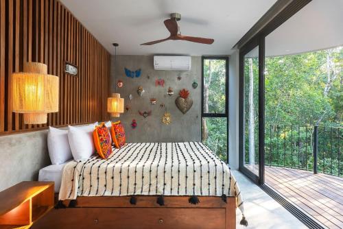 a bedroom with a bed and a large window at Luxury 4BR Eco Villa 10ppl Outdoor Pizza Oven - Private Pool & Jacuzzi in Tulum